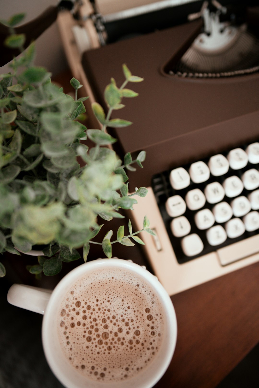 Cozy writer's desk with a typewriter, books and coffee cup
